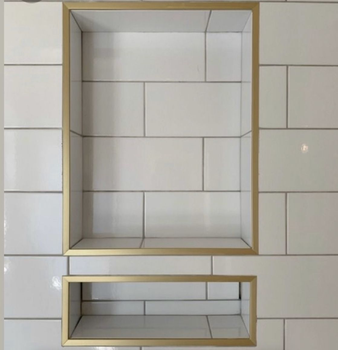 Gold-framed shelves against a tiled wall